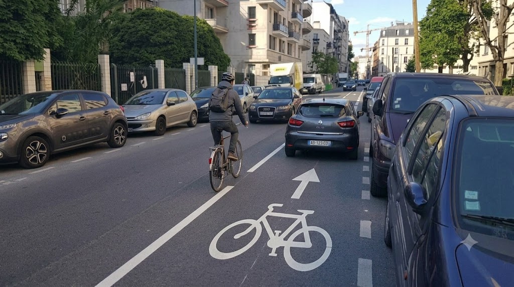 Une voiture coupe dangereusement la trajectoire d'un cycliste en ville
